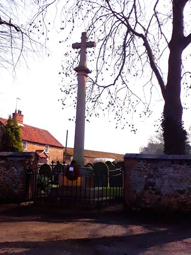 A photo of the Wereham War Memorial. Has remembrance wreaths placed on it within the picture.